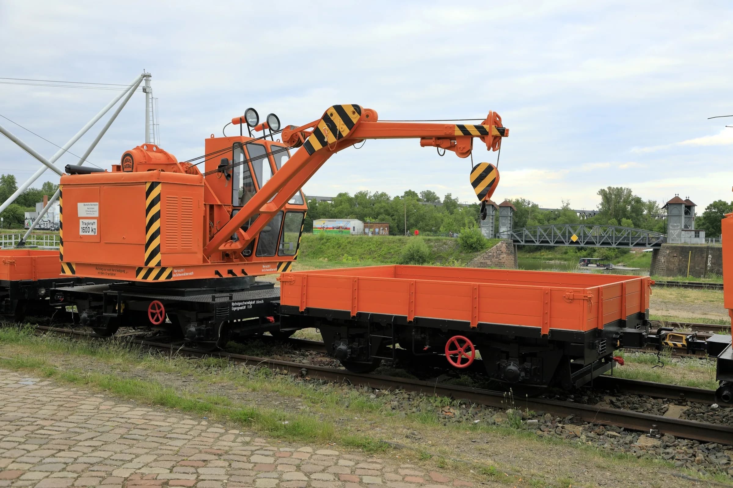 Eisenbahn-Drehkran mit Niederbord-Ladewagen beim Verladen im Gleisbereich